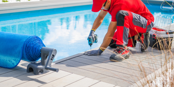 Professional Swimming Pools Worker Finishing Composite Outdoor Pool Deck Installation. SPA Industry Theme.